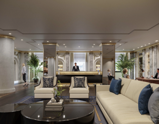 a lobby with a man standing behind a reception desk